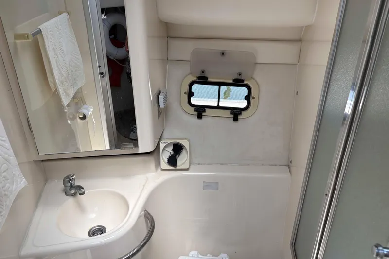 Slide: The Image of 2001 Bayliner 3258 Command Bridge bathroom with sink, mirror, and porthole window. - 28