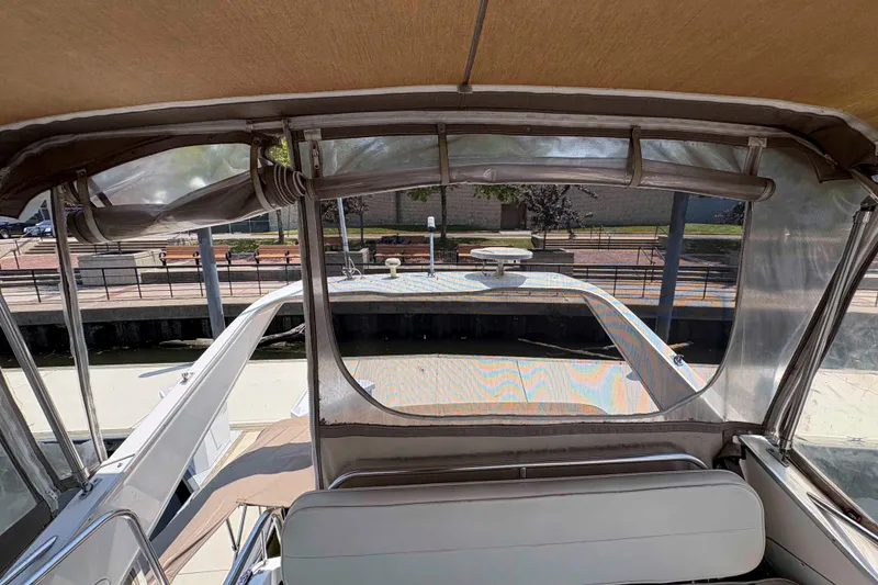 Slide: The Image of 2001 Bayliner 3258 Command Bridge interior view with clear canopy and dockside background. - 13