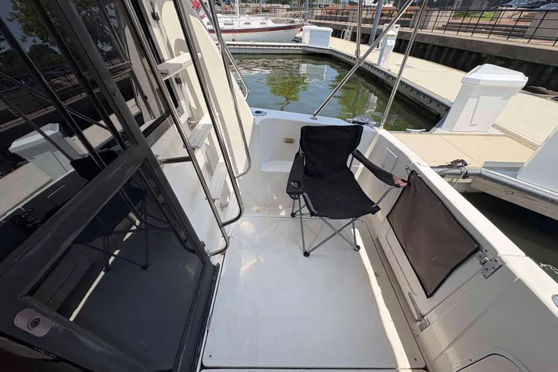 Slide: The Image of 2001 Bayliner 3258 Command Bridge cockpit with folding chair, docked at marina. - 15
