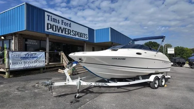The Image of A 2005 Regal 2400 LSR boat on a trailer in front of a powersports store. - 1
