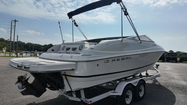 Slide: The Image of 2005 Regal 2400 LSR on a trailer, featuring a Bimini top and outboard motor. - 5