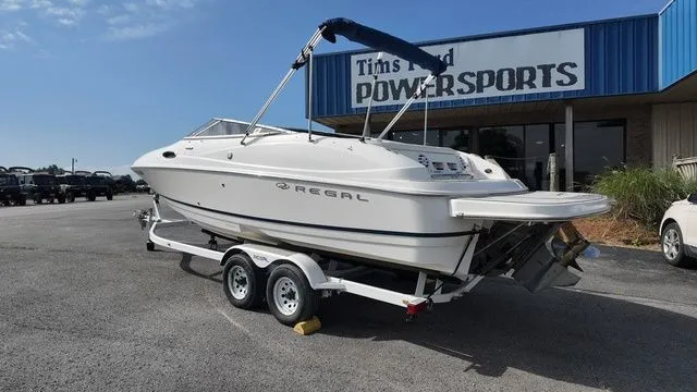 Slide: The Image of A 2005 Regal 2400 LSR boat on a trailer in front of a store. - 2