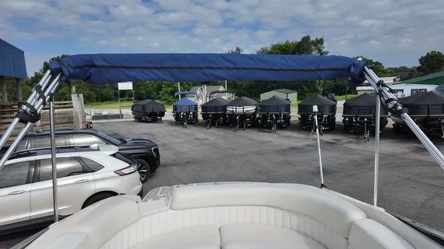 Slide: The Image of The image shows the cockpit of a 2005 Regal 2400 LSR boat with a blue sunshade. - 24