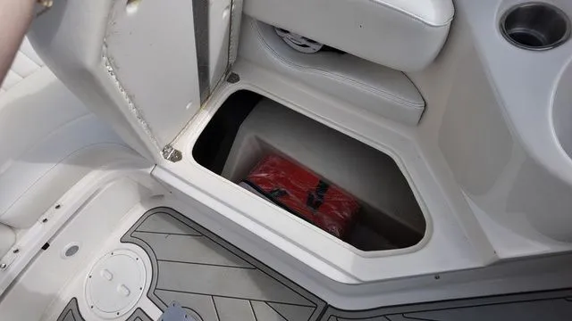 Slide: The Image of A 2005 Regal 2400 LSR boat with an open storage compartment containing a red package. - 20