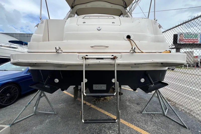 Slide: The Image of Rear view of a 2002 Sea Ray 340 Sundancer boat on stands, showcasing its swim platform and ladder. - 13