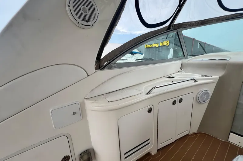 Slide: The Image of 2002 Sea Ray 340 Sundancer cockpit with storage cabinets and speakers. - 26