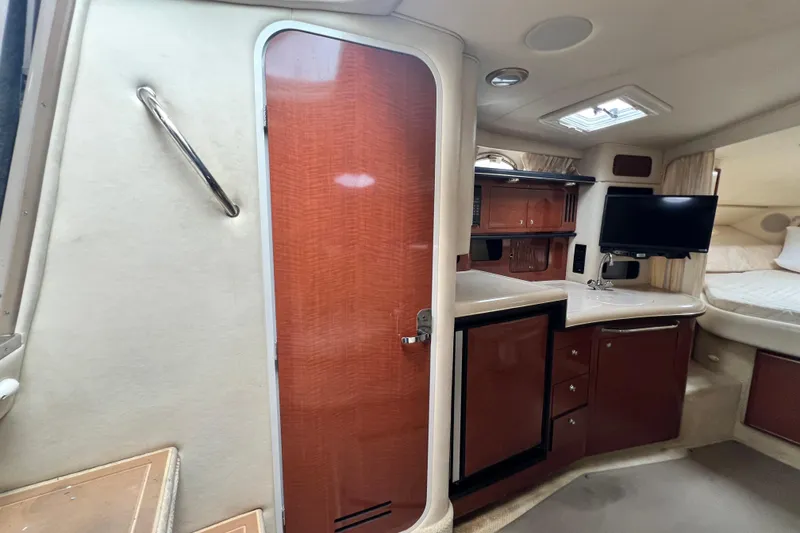 Slide: The Image of Interior of 2002 Sea Ray 340 Sundancer with kitchenette, TV, and wood cabinetry. - 36