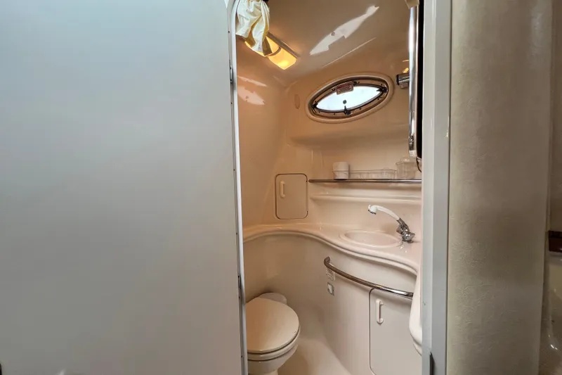 Slide: The Image of 2002 Sea Ray 340 Sundancer bathroom with sink, toilet, and oval window. - 37