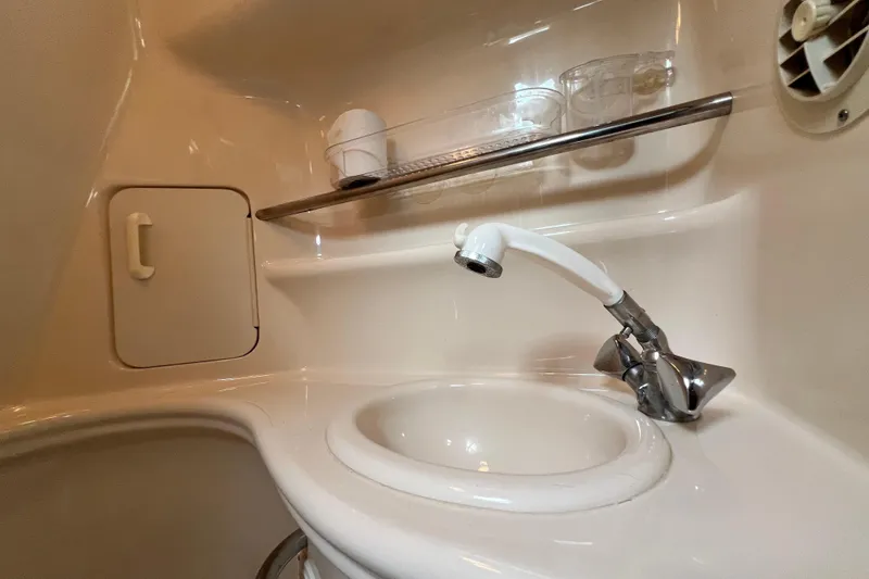 Slide: The Image of 2002 Sea Ray 340 Sundancer bathroom sink with faucet and storage shelf. - 38