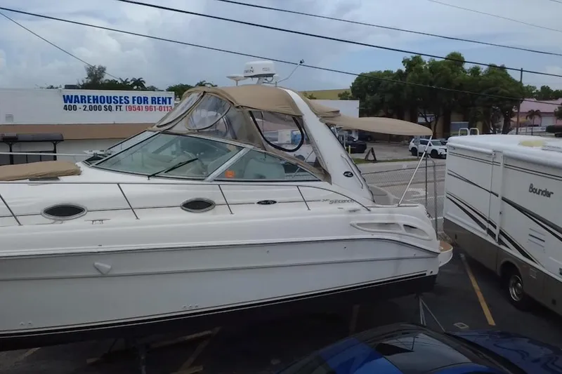 Slide: The Image of 2002 Sea Ray 340 Sundancer boat parked near RV and warehouse for rent sign. - 7