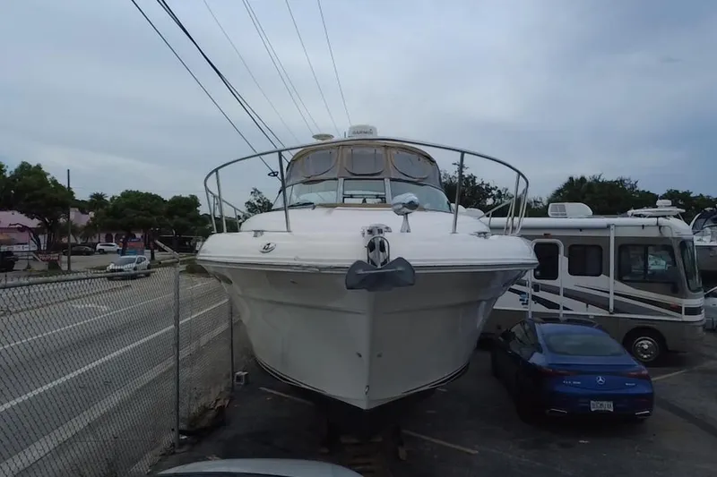Slide: The Image of 2002 Sea Ray 340 Sundancer yacht parked near road and vehicles. - 8
