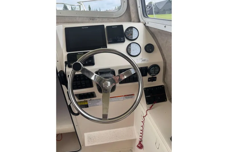 Slide: The Image of Helm of 2020 Defiance San Juan 250 boat with steering wheel and navigation instruments. - 13