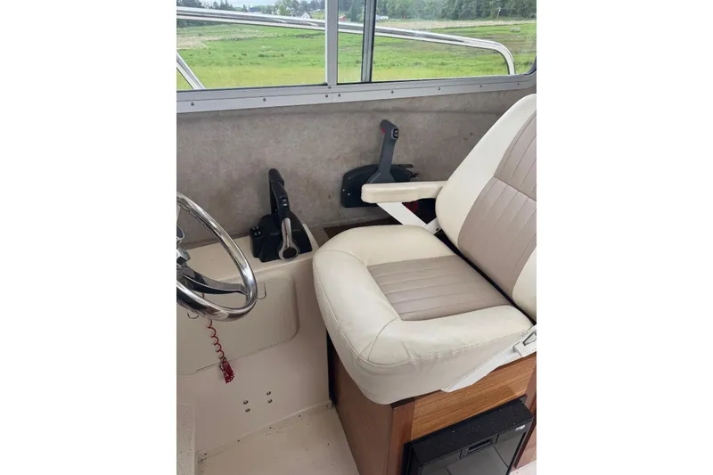 Slide: The Image of Interior of 2020 Defiance San Juan 250 boat with steering wheel and captain's chair. - 14