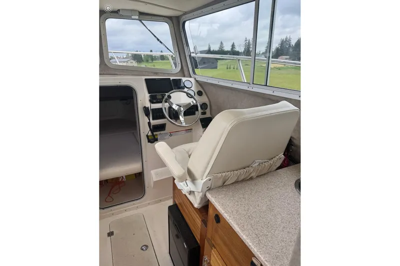 Slide: The Image of Interior of 2020 Defiance San Juan 250 boat with steering wheel and captain's chair. - 15