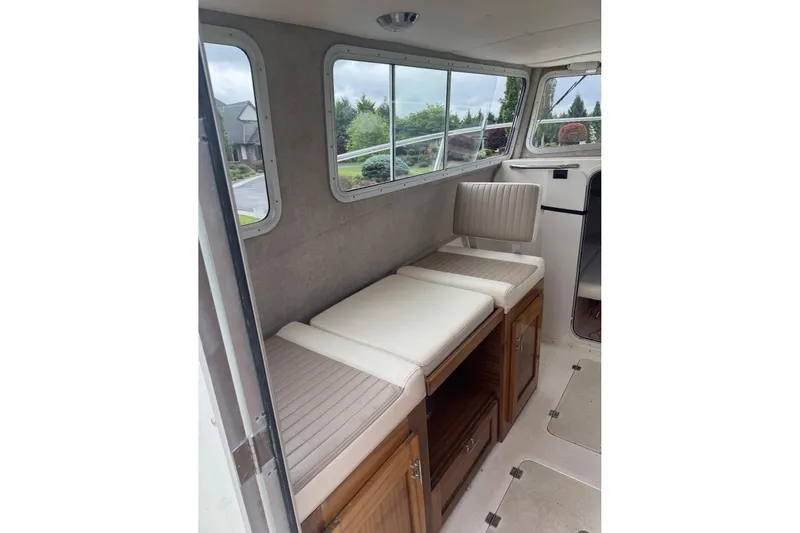 Slide: The Image of Interior of 2020 Defiance San Juan 250 boat with cushioned seating and wooden storage. - 16