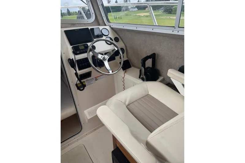 Slide: The Image of Interior cockpit of 2020 Defiance San Juan 250 boat with steering wheel and controls. - 19