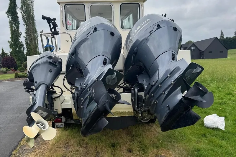 Slide: The Image of 2020 Defiance San Juan 250 boat with Yamaha outboard motors on grassy area. - 2
