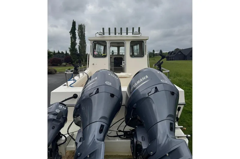 Slide: The Image of 2020 Defiance San Juan 250 boat with dual Yamaha outboard motors, parked outdoors. - 3