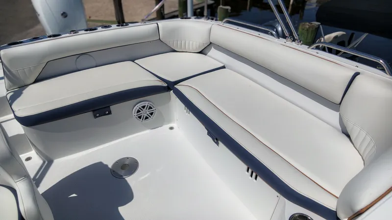 Slide: The Image of The image shows a boat's seating area with white upholstery and blue accents. - 7