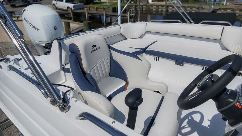 Slide: The Image of The image shows the cockpit of a 2027 Stingray 192 SC boat with white and blue seating. - 21