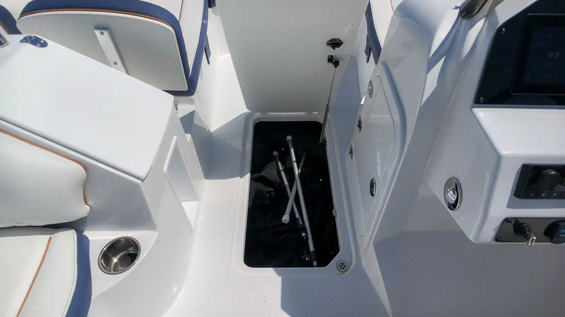 Slide: The Image of The image shows the storage compartment of a 2027 Stingray 192 SC boat. The compartment is open and contains some items. - 13