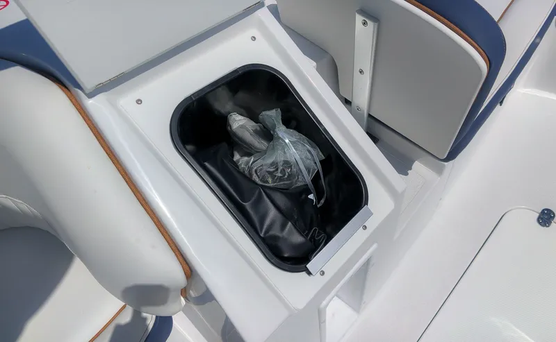 Slide: The Image of A storage compartment on a boat containing a plastic bag and other items. - 12