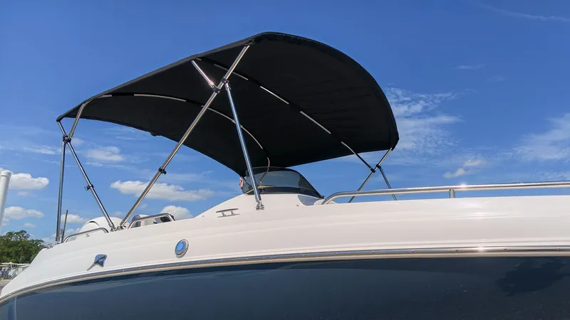 Slide: The Image of A Stingray 192 SC boat with a black bimini top under a blue sky. - 2
