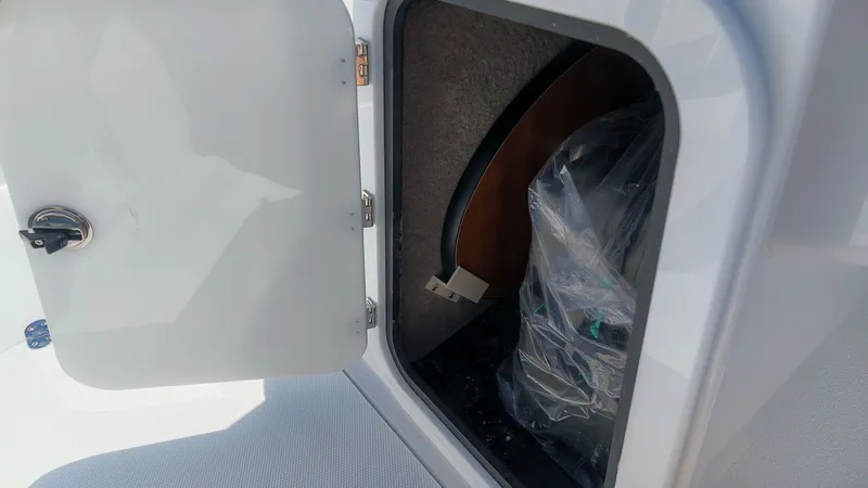 Slide: The Image of An open storage compartment on a boat with a plastic bag inside. - 14
