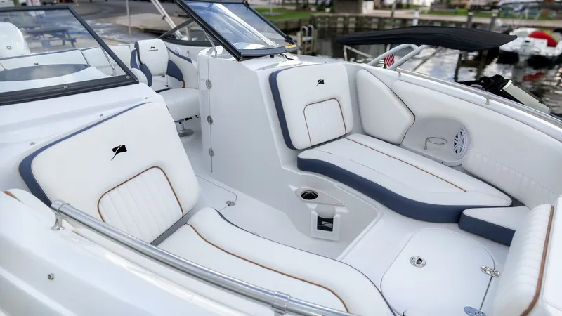 Slide: The Image of The image shows the cockpit of a 2027 Stingray 211 DC boat with white and blue seating. - 8