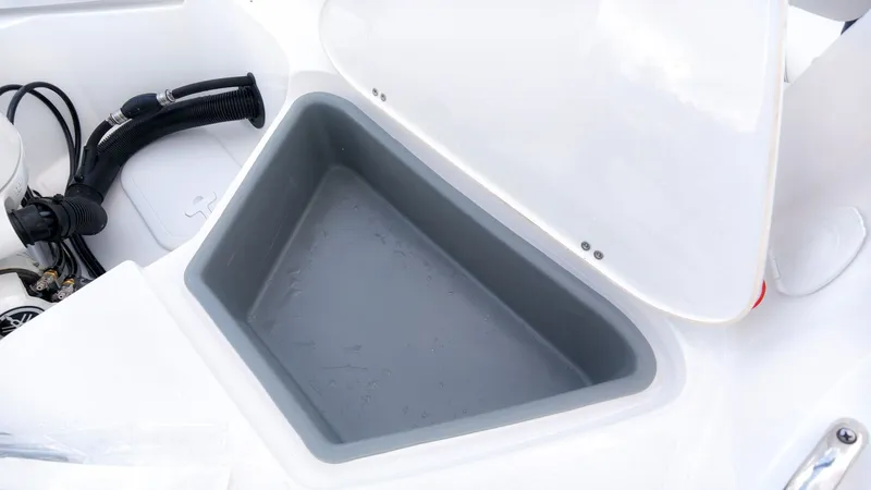 Slide: The Image of An open storage compartment on a boat with a gray interior and white surfaces. - 11