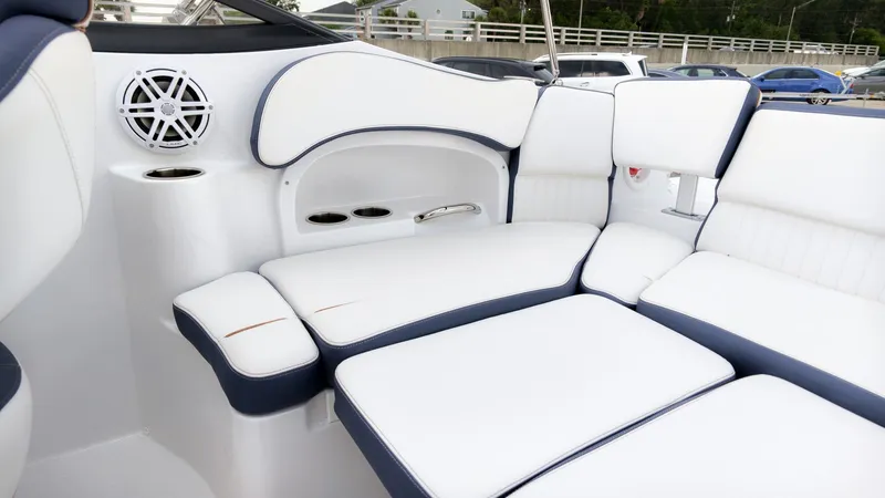 Slide: The Image of The image shows the luxurious white and blue seating area of a Stingray 211 DC boat. - 20