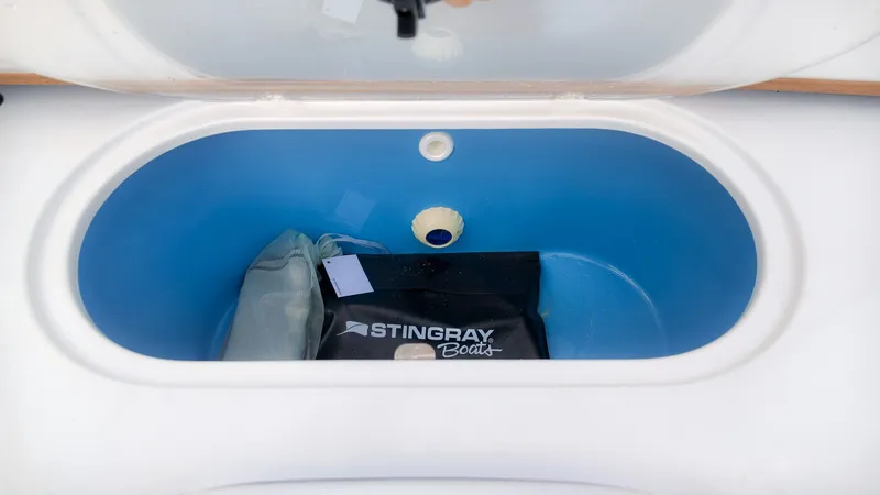 Slide: The Image of A blue storage compartment with a Stingray Boats bag and a small item. - 15