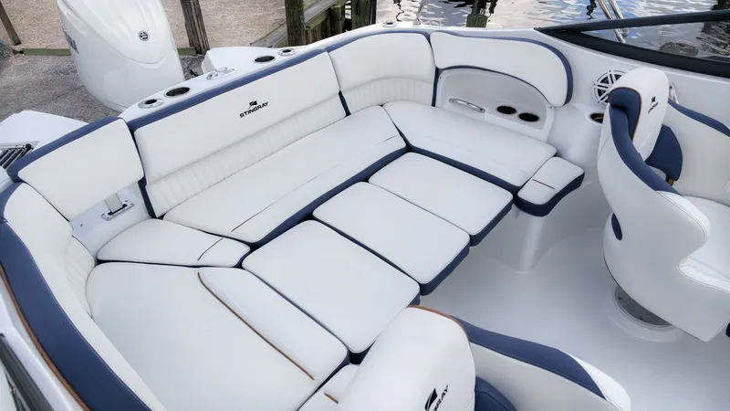 Slide: The Image of The image shows the interior of a 2027 Stingray 211 DC boat with white upholstery. - 7