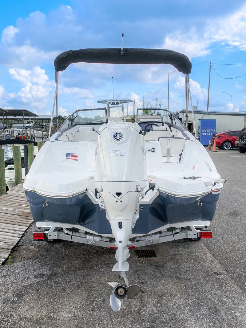 Slide: The Image of The image shows a 2027 Stingray 211 DC boat with an outboard motor, docked at a pier. - 5
