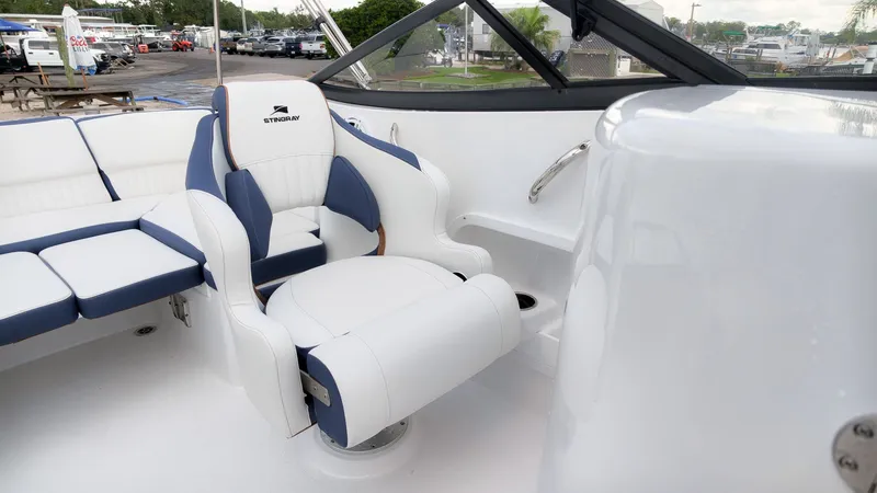 Slide: The Image of The image shows the interior of a Stingray 211 DC boat with white and blue seating. - 16