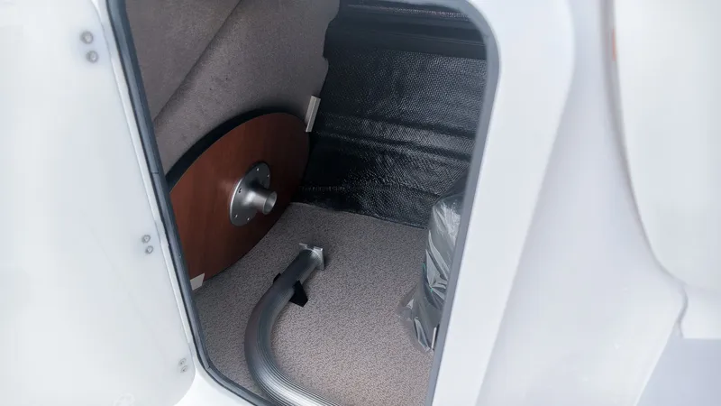 Slide: The Image of Interior of a boat with carpeted floor and a round wooden table. A flexible hose is visible. - 19