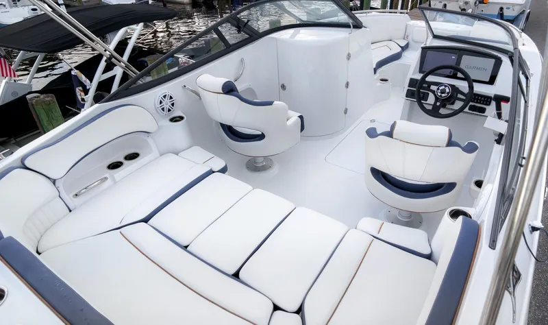 Slide: The Image of The image shows the cockpit of a 2027 Stingray 211 DC boat with white upholstery and a modern helm. - 6