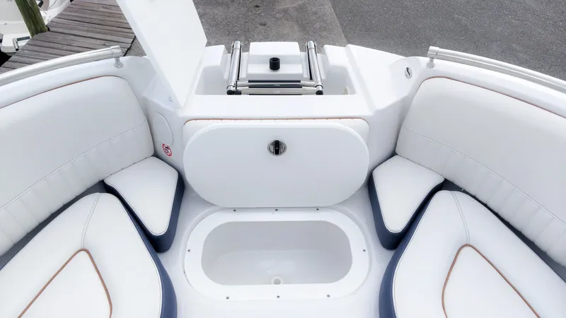 Slide: The Image of The image shows the bow area of a Stingray 211 DC boat with white upholstery and storage. - 22