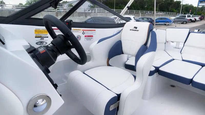 Slide: The Image of The image shows the cockpit of a Stingray 211 DC boat with a white and blue seat. - 25