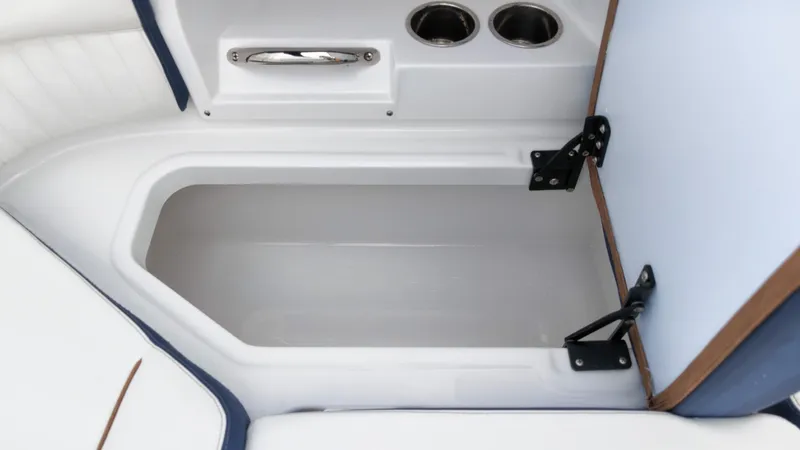 Slide: The Image of An open storage compartment on a boat with two cup holders beside it. - 14