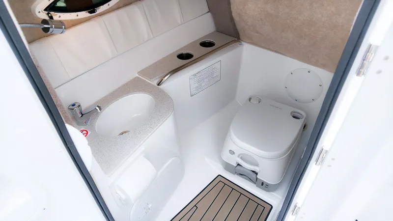 Slide: The Image of The image shows a modern boat bathroom with a sink, toilet, and storage area. - 17