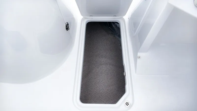 Slide: The Image of An open storage compartment with gray carpet inside a boat. - 18