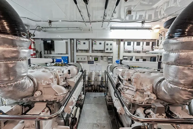 Slide: The Image of Engine room of 2012 Ocean Alexander 90 Skylounge Motoryacht, featuring dual engines and control panels. - 100