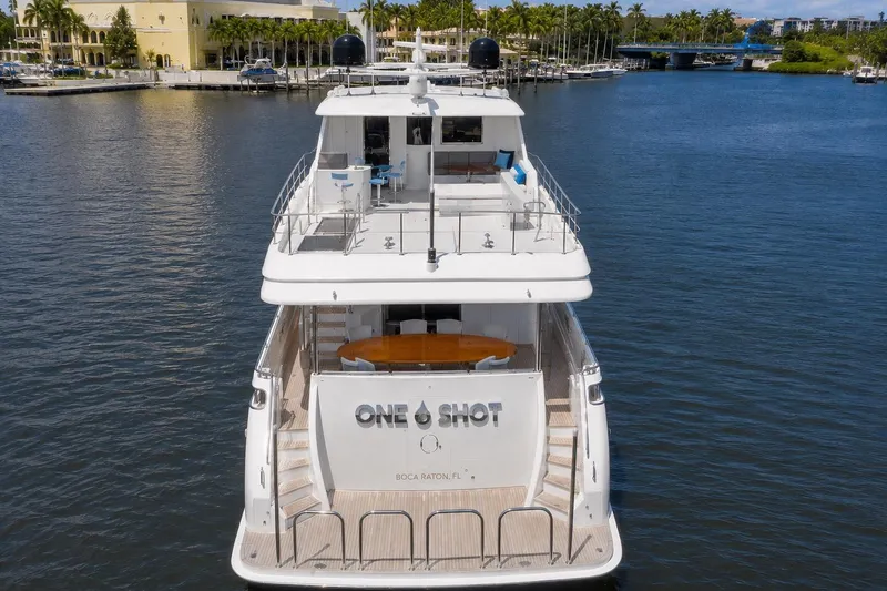 Slide: The Image of 2012 Ocean Alexander 90 Skylounge Motoryacht on water, rear view, docked near palm trees. - 10