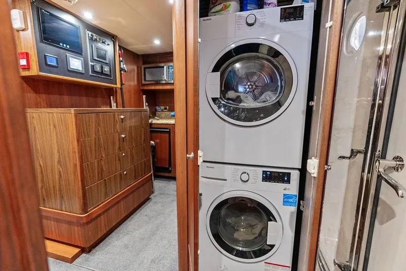 Slide: The Image of Laundry area inside 2012 Ocean Alexander 90 Skylounge Motoryacht with stacked washer and dryer. - 92