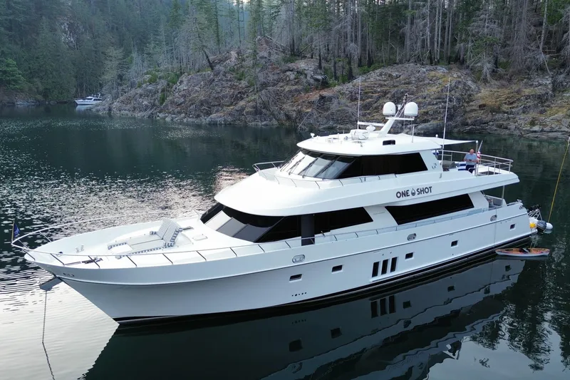 Slide: The Image of Luxurious 2012 Ocean Alexander 90 Skylounge Motoryacht anchored in a serene, forested cove. - 2