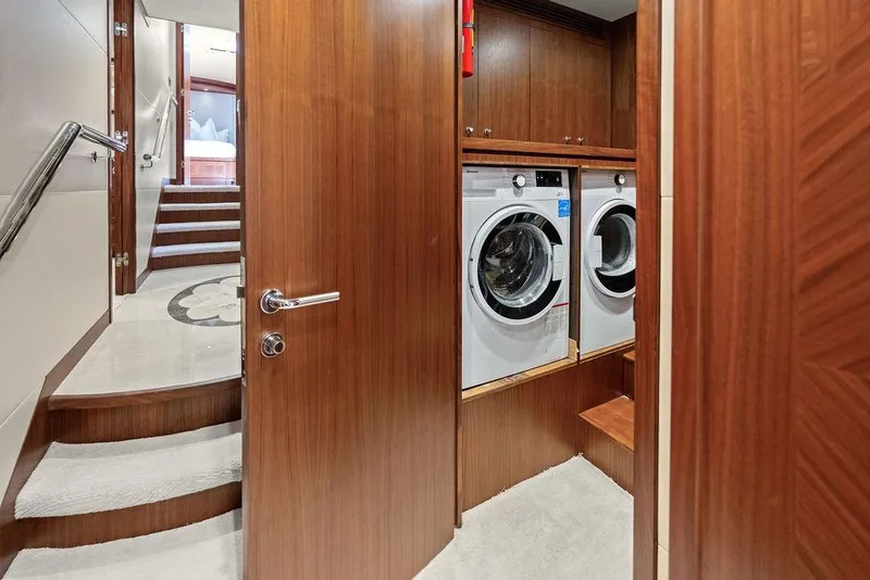 Slide: The Image of Laundry area on 2012 Ocean Alexander 90 Skylounge Motoryacht with wood paneling and stairs. - 91