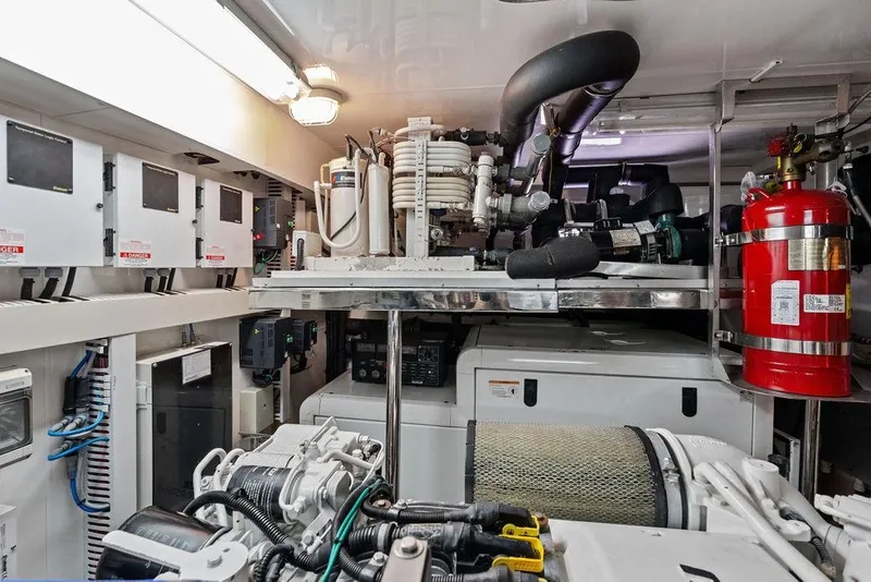 Slide: The Image of Engine room of 2012 Ocean Alexander 90 Skylounge Motoryacht, featuring equipment and fire extinguisher. - 104