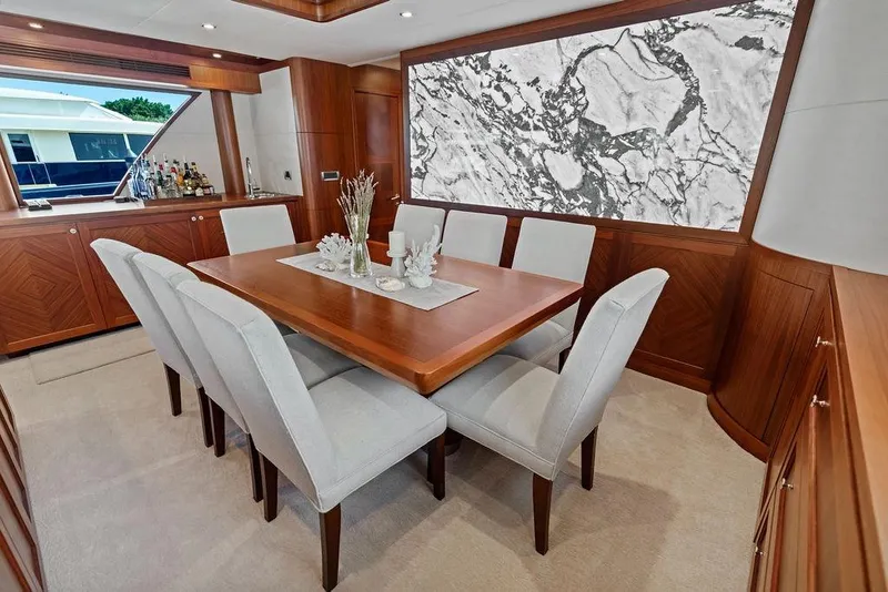 Slide: The Image of Luxurious dining area in 2012 Ocean Alexander 90 Skylounge Motoryacht with elegant wood finishes. - 56