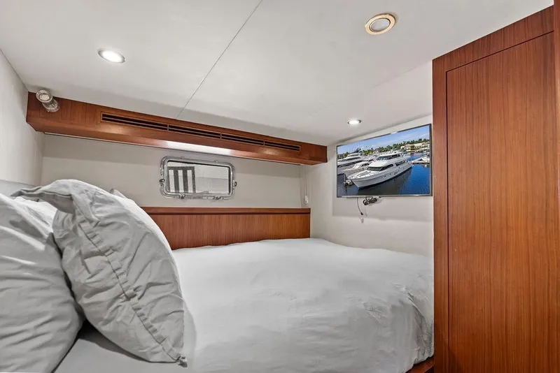 Slide: The Image of Luxurious bedroom in 2012 Ocean Alexander 90 Skylounge Motoryacht with TV and wood accents. - 95